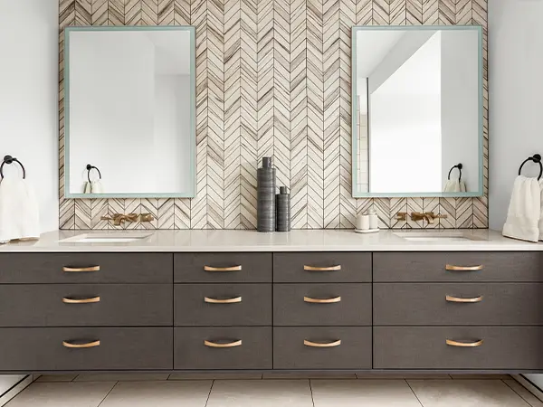 A gray double vanity with golden hardware