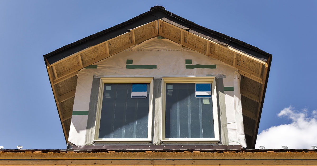 Two windows on the upper level of a home being remodeled