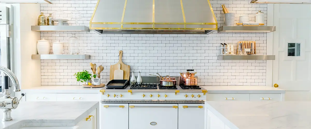 A kitchen with white and gold features