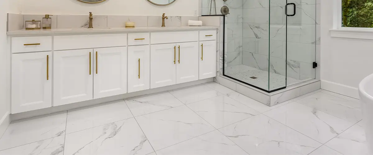 A beautiful bathroom with a large vanity, a glass shower, and a tile floor