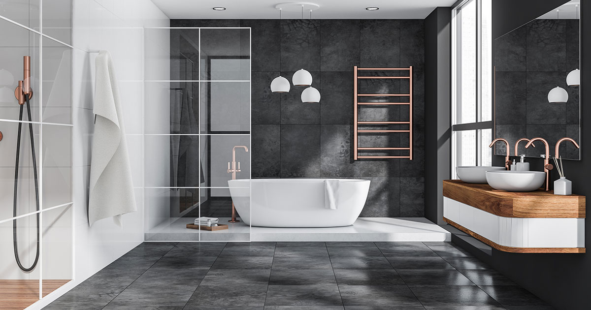 An upscale bathroom with black tile floor and walls and large tub