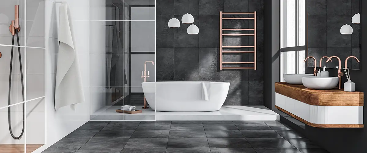 An upscale bathroom with black tile floor and walls and large tub