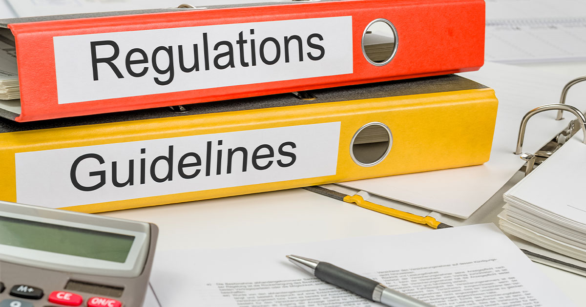 Two binders labeled 'Regulations' and 'Guidelines' on shelf