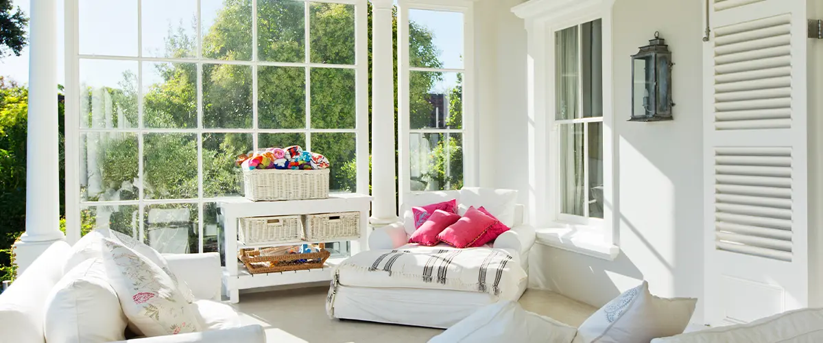 Bright and cozy white home addition in West Covina, with large windows, cushioned seating, and vibrant pillows, perfect for relaxation.