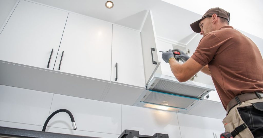 man installing kitchen cabinets