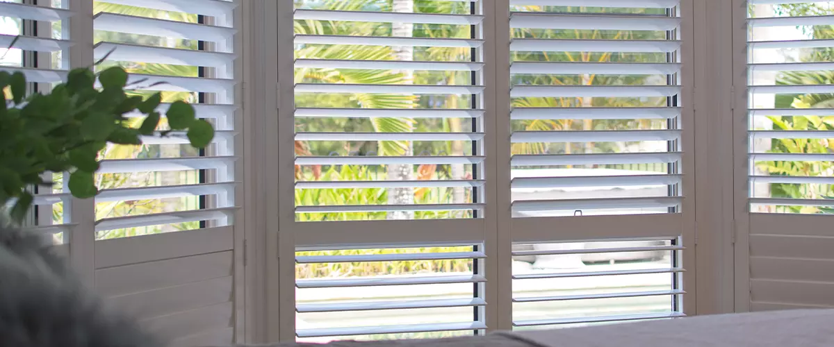 Luxury white indoor plantation shutters in bedroom