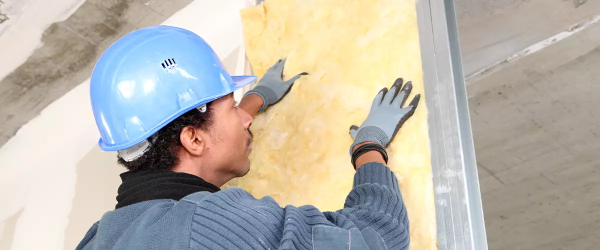 Man fitting wall insulation