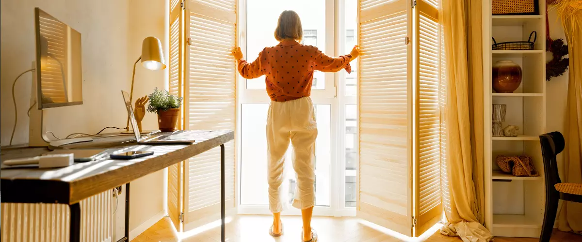 window blinds letting the sun inside the room, spending good morning in sunny and cozy apartment in beige tones