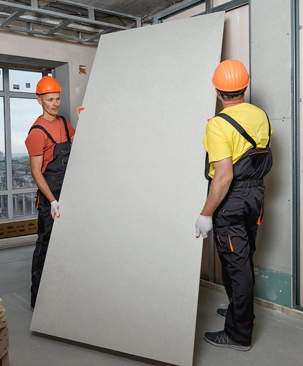 Two construction workers working on walls from home building company