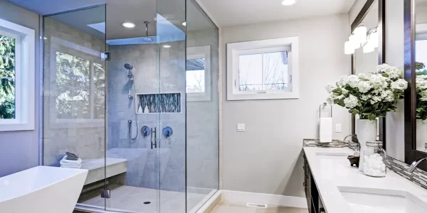 Modern bathroom with a large glass-enclosed shower, freestanding tub, and double vanity.